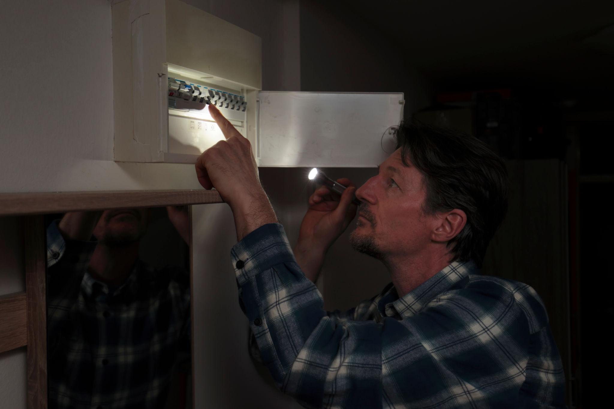 Elektriker prüft einen Sicherungskasten